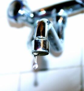 Leaking faucet with a dripping water drop indicating a potential plumbing issue
