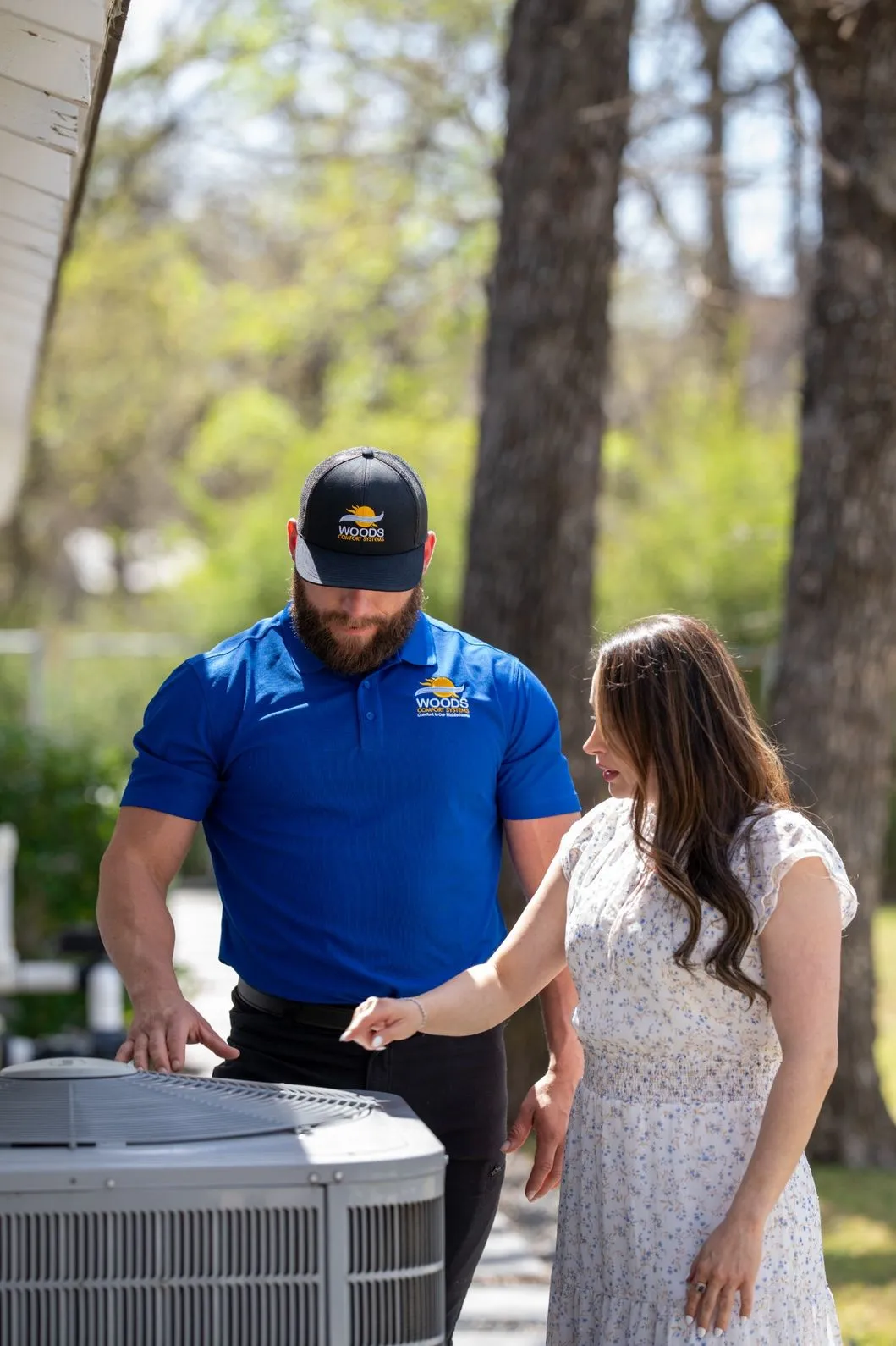 HVAC technician explaining AC unit inspection to homeowner during service